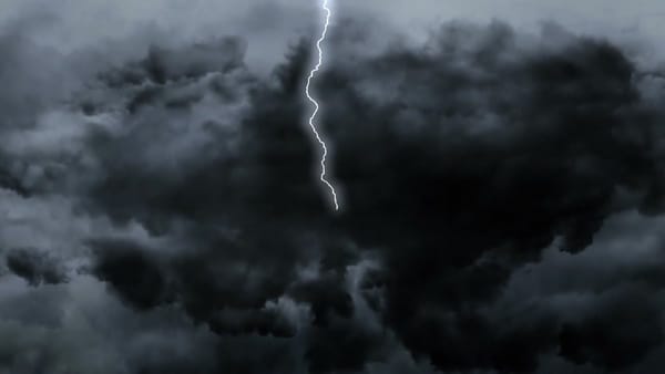 Lightning striking through dark storm clouds